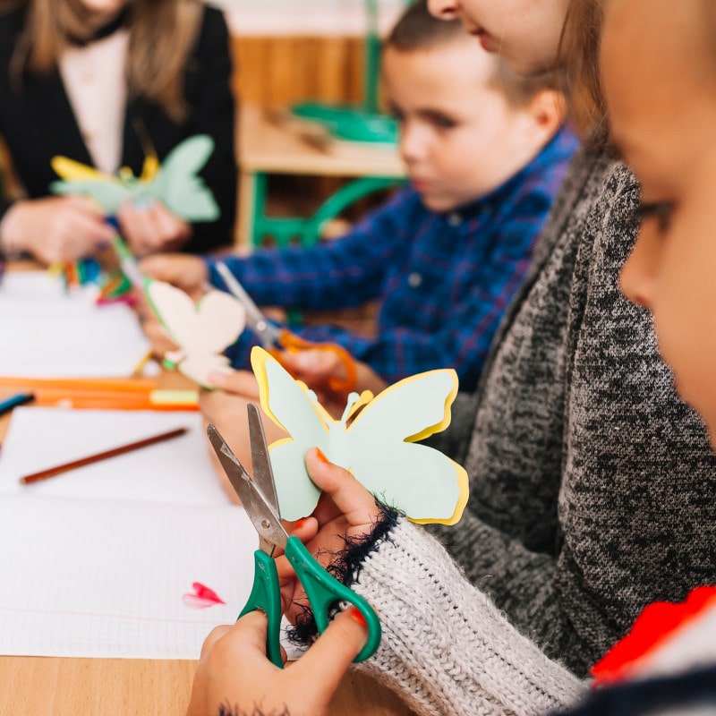 Niños recortando mariposas de papel