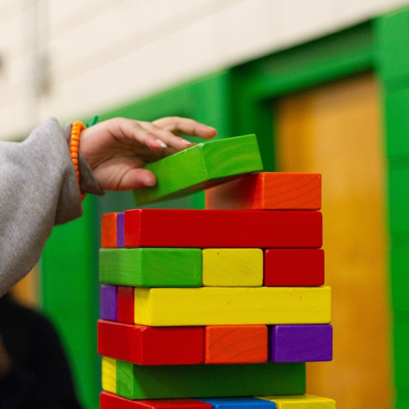 Mano de niño jugando con bloques de colores